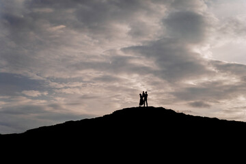 Family Silhouettes Standing Togetherness on Hill
