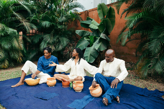 African female teacher teaching her team of entrepreneurs how to eco dye their organic fabrics