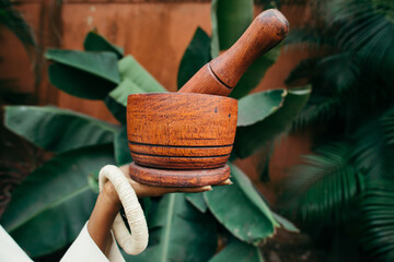 african woman holding pestle and mortar in nature