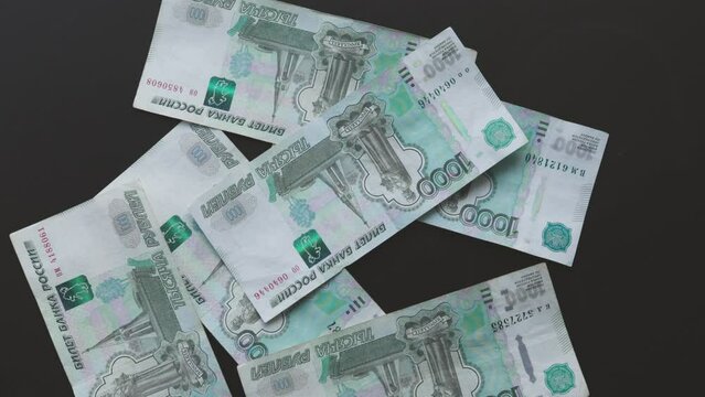 1000 rubles one thousand Russian rubles banknotes paper money falling on black background table. russia currency. exchanging rate, concept economics finance business. global trade commerce