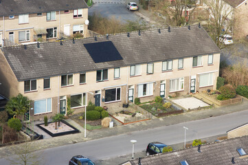 Terraced houses in residential area with brown roof and one solar panel from above in Arnhem in the Netherlands