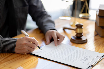Attorneys are reviewing contract documents for the client, in which the client has filed a lawsuit against an employee at a company that commits the fraud. Lawyer and use of law properly and fairly.