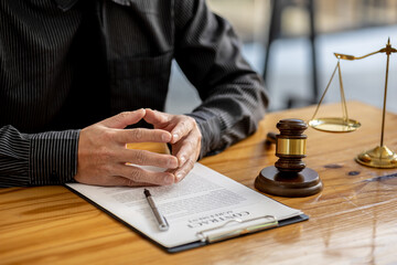 A lawyer sits in his office, on a table with a small hammer to beat the judge's desk in court. and...
