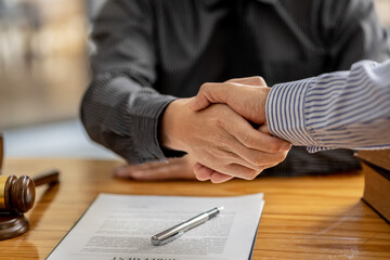 Lawyers shake hands with clients who come to testify in the case of embezzlement from business...