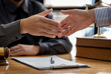 Lawyers shake hands with clients who come to testify in the case of embezzlement from business...
