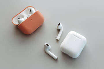 Fototapeta premium White wireless bluetooth earphones or headphones, plastic case or box for storage and charging