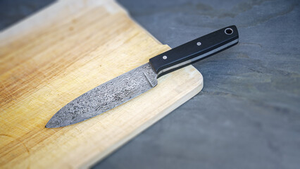Damascus steel knife on a wooden board
