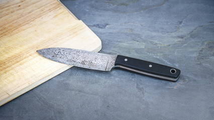 Damascus steel knife on a wooden board