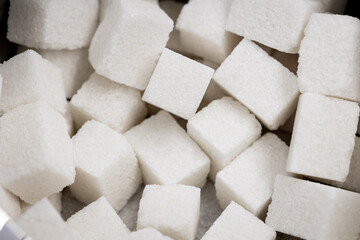 Cubes of white refined sugar in a bowl top view close-up