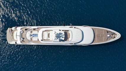 Aerial drone ultra wide photo of luxury yacht with wooden deck and helipad anchored near port of...