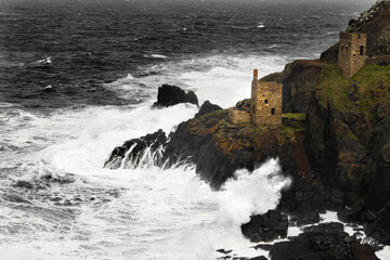 Stormy Botallack tin mine, Cornwall. The famed Crowns engine houses clinging to the foot of the cliffs. Part of the Cornish Mining World Heritage Site and Poldark filming location