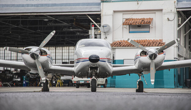 Front shot of a modern white aircraft plane on the kand with colorful lights on a sunny day