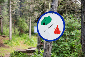 Camping zone sign in the woods. Space for tent and campfire