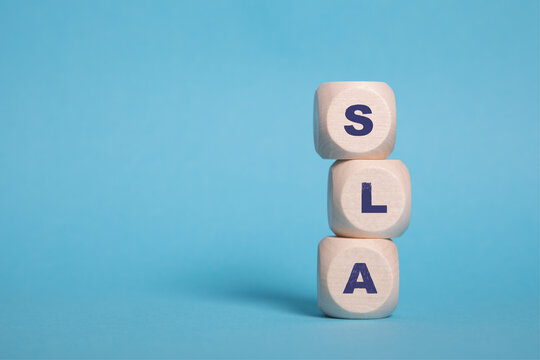 SLA, Service Level Agreement Acronym on wooden blocks isolated on blue background, copy space.