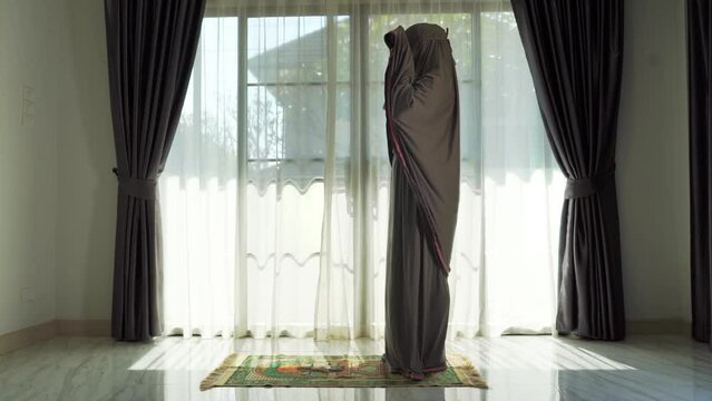 An elderly Muslim man with a gray beard prays at home during the coronavirus pandemic. Covid-19, quarantine concept	