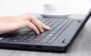 Close up of businessman's fingers on laptop keyboard