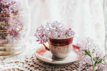 Retro tea cup with lilac flowers in it. Home decoration. Springtime vibes