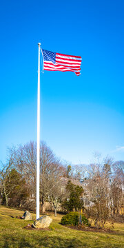 Cellphone or smartphone backdrop image with the American flag waving big over the green garden. Patriotic memorial park landscape on Cape Cod, Massachusetts.