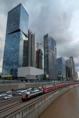 Cloudy gloomy Tel Aviv city before the sunset. Modern glass skyscrapers and automobile Ayalon highway. Electric train