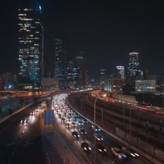 Fototapeta na wymiar Tel Aviv city at night. Modern glass buildings and speed highway