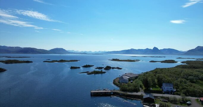 Arial pan over small Norwegian harbor with panoramic view over small islands in Ringstad bo I Vesteralen - Northern Norway - Langoya. Idyllic summer day.