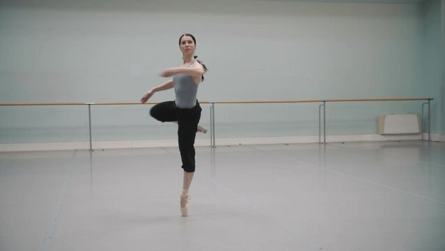 beautiful professional ballerina rehearsing in an empty hall. Slow motion