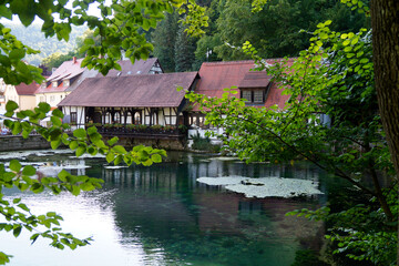 Fototapeta na wymiar Ancient blacksmith's shop by the turquois pond called Blautopf (Blue Pot) in Blaubeuren (Germany)