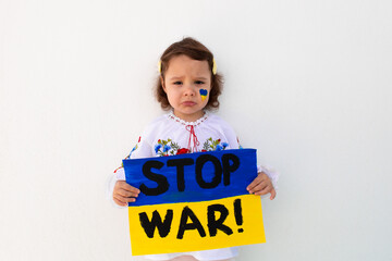 A portrait of a girl in an embroidered shirt calls to stop the war in Ukraine, raises a banner with the inscription 