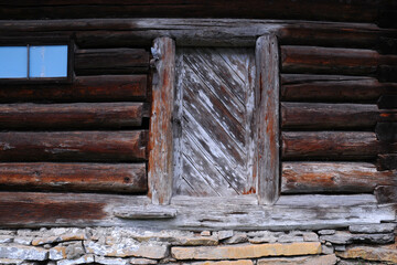 An old hut, a wall made of wooden logs, a destroyed door, somebody living ... 
