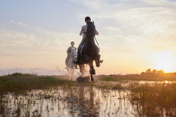 Horses lend us the wings we lack. Shot of two young women riding their horses outside on a field. - Powered by Adobe