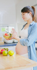 Obraz na płótnie Canvas Asian pregnant woman prepare salad