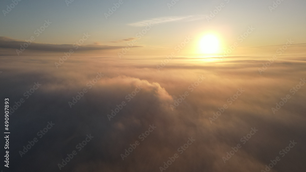 Poster Aerial shot of dense clouds at scenic sunset