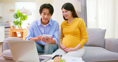 asian pregnant couple use computer