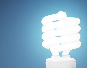 Conserve your energy. Studio shot of an energy saving lightbulb against a blue background.