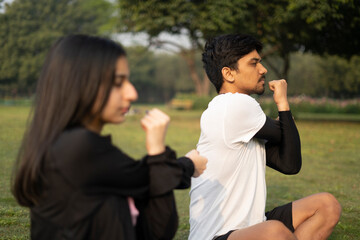 An indian young couple doing yoga early in the morning, boy and girl doing yoga in the park.Healthy lifestyle concept.