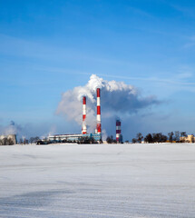 industrial pipes with white smoke in winter