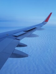 Obraz premium Airplane wing in the blue sky