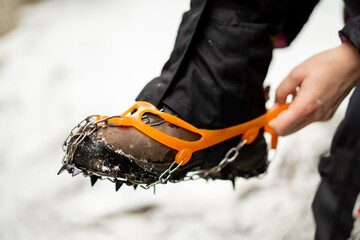 Close up of snow shoes and shoe spikes in winter. 
Hiking, concept during outdoor winter trekking...