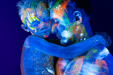 Young father and son. Painted with fluorescent paint using UV light