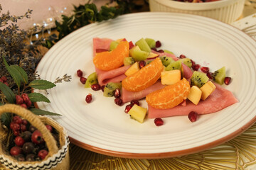 Pancakes. Pink sweet dough with fruits and honey. Tangerines, kiwi, pomegranate seeds. Floral background. Delicious breakfast at home or in a cafe. Selective focus. Shrovetide menu. carnival baking