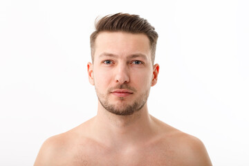 Obraz premium Portrait of a naked young man with stubble on a white background.