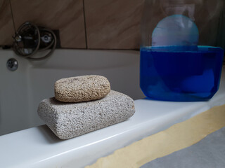 two pumice stones on top of each other on a bath tub