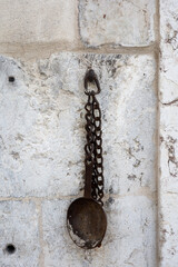 rusty ladle on a historic wall