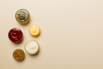 Different types of sauces in bowls on a colored Board . Top view. various sauces copy space