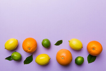 Fruit background. Colorful fresh fruits on colored table. Orange, lemon, grapefruit Space for text healthy concept. Flat lay, top view, copy space