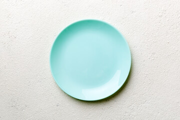 Top view of empty blue plate on cement background. Empty space for your design