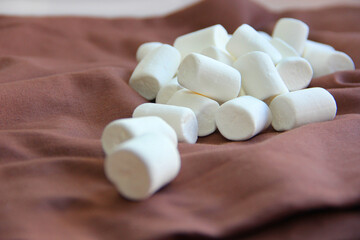 Fototapeta na wymiar marshmallow white on a chocolate background