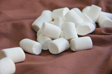 Fototapeta na wymiar marshmallow white on a chocolate background