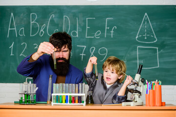 Innovation and Excellence. Little kid learning chemistry in school laboratory. Back to school. school kid scientist studying science. teacher man with little boy. father and son at school