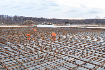 The foundation slab is made of reinforcement rods, bound with tie wire, visible sewage pipes.